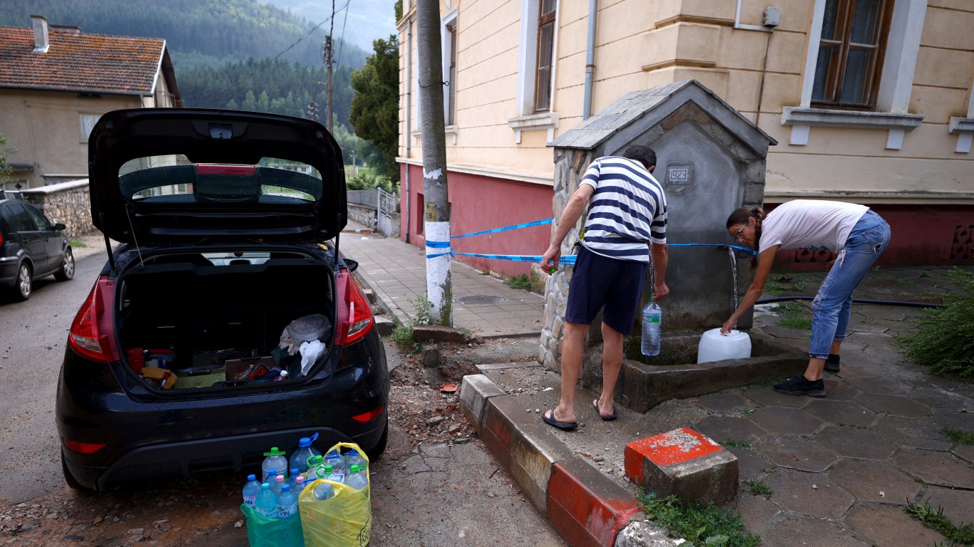 Местните хора си наливат изворна вода от чешма в село Искрец, 17 август